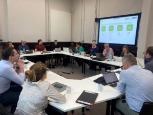 People sitting at desks discussing the digital solutions hub as part of the health and environment use case workshop.